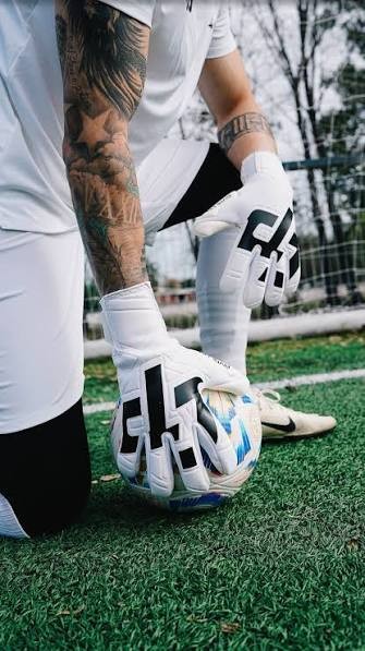 Arquero con guantes sobre la pelota
